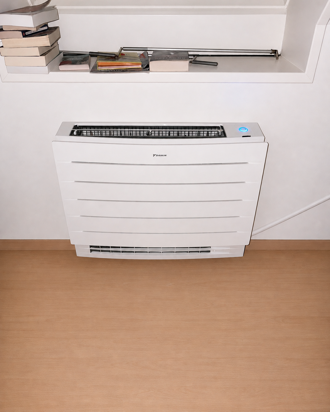 Console de climatisation Daikin Perfera installée sous une fenêtre dans une chambre