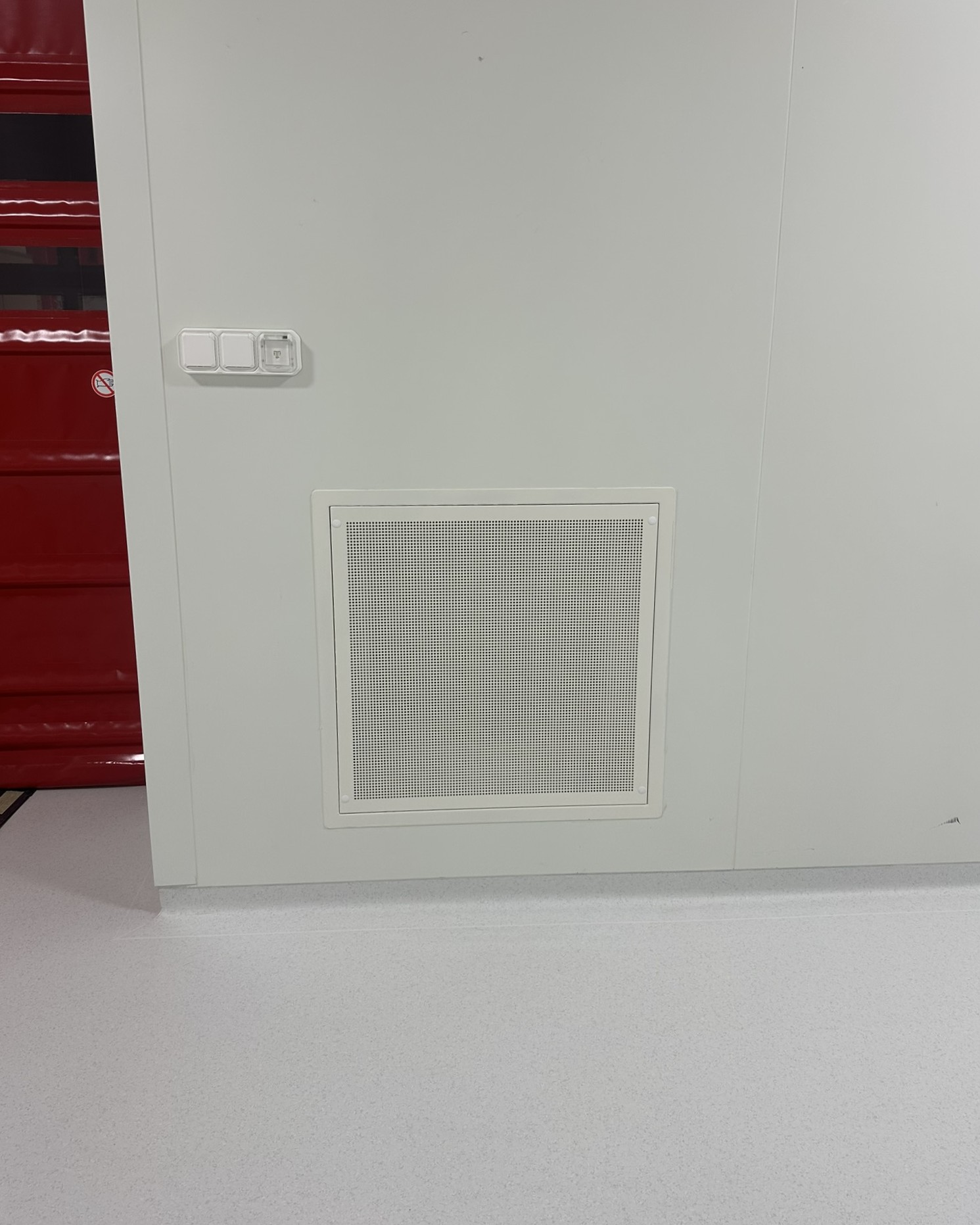 Grille de reprise d'air murale installée près d'un poste de commande dans une salle propre