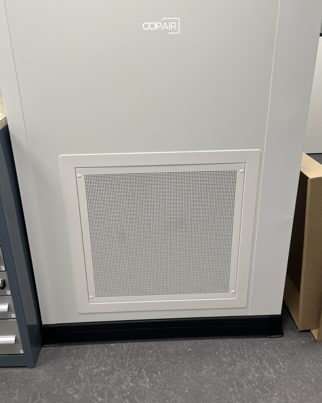 Grille de reprise d'air murale installée dans une salle de métrologie industrielle climatisée, COPAIR